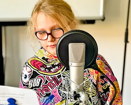 Kind steht hinter dem Mikrofon