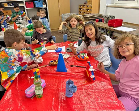 Kinder sitzen am Gruppentisch und filzen